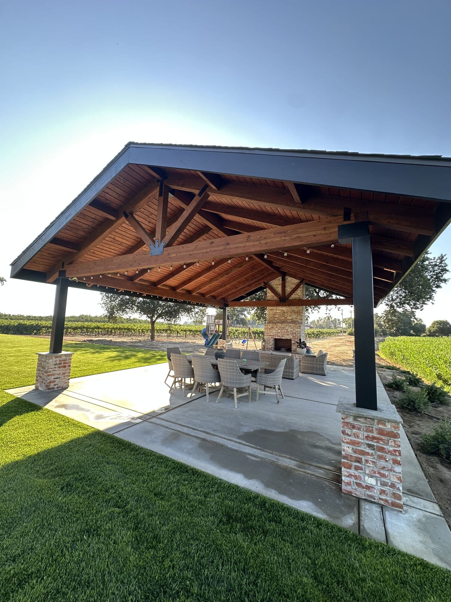 A covered outdoor pavilion with exposed timber trusses built by CG Construction